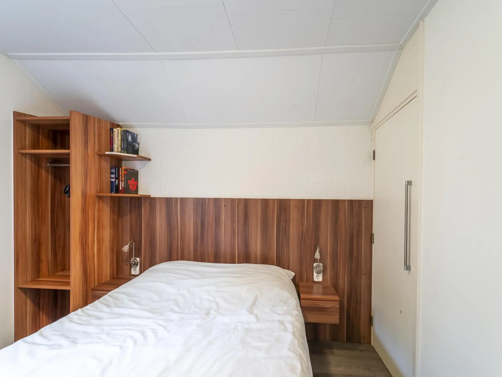 Bedroom with a double bed, bookshelf and timber wardrobe