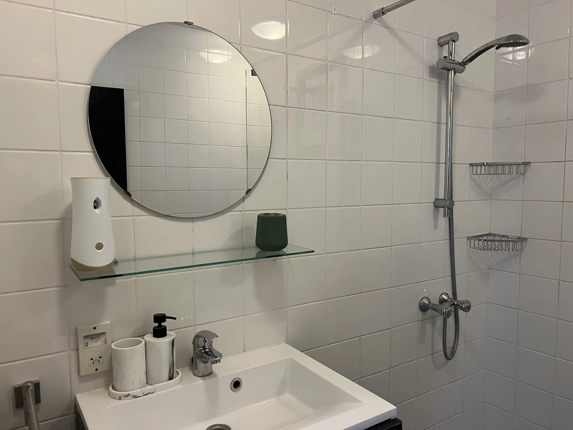 Bathroom with a round mirror and shower