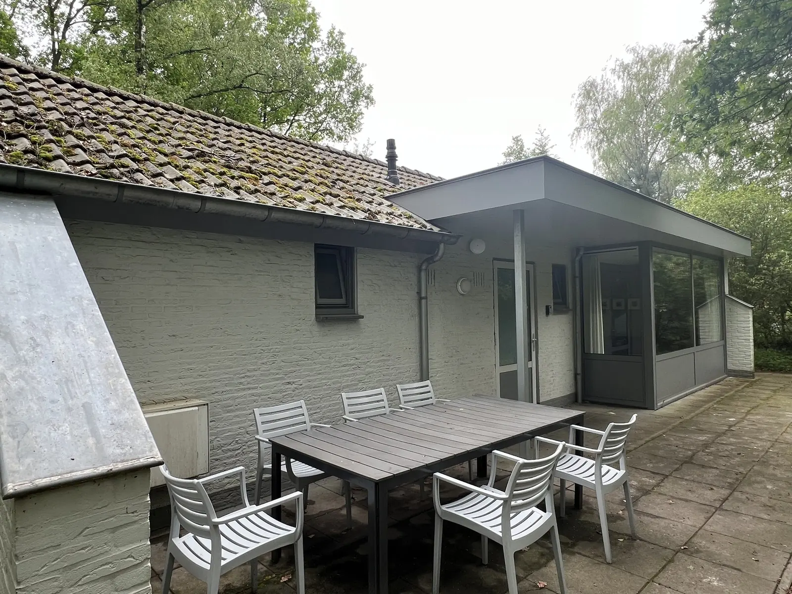The terrace: a table with six chairs along the white wall