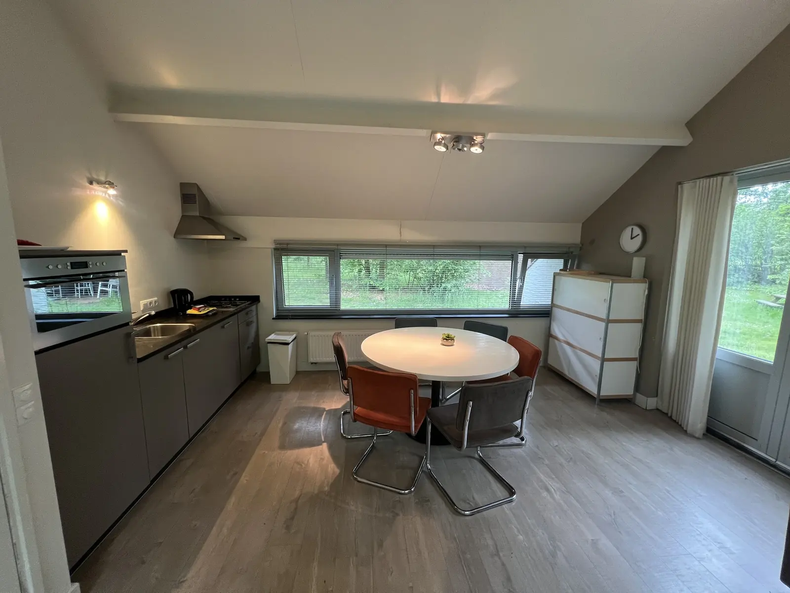 The kitchen units and the oval dining table with six chairs