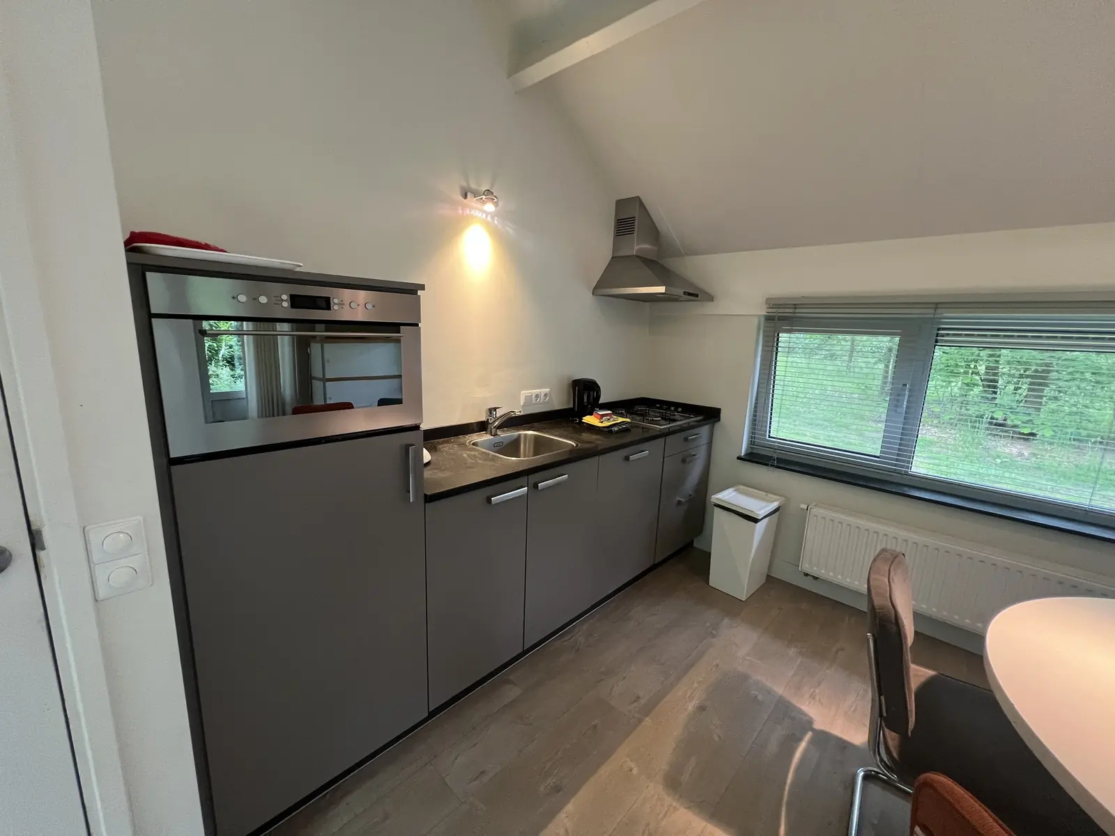 Kitchen with oven, sink and gas hob under the extractor hood