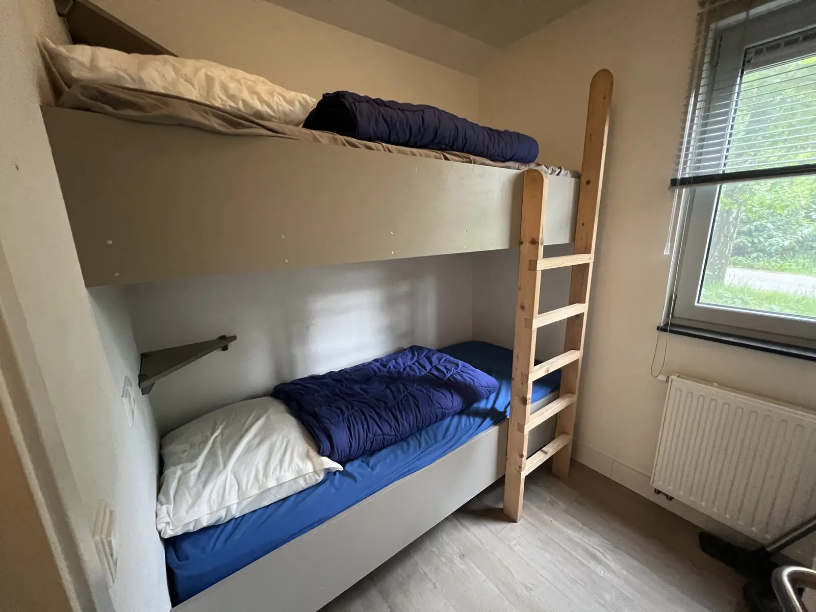 Room with a bunk bed and a wooden ladder