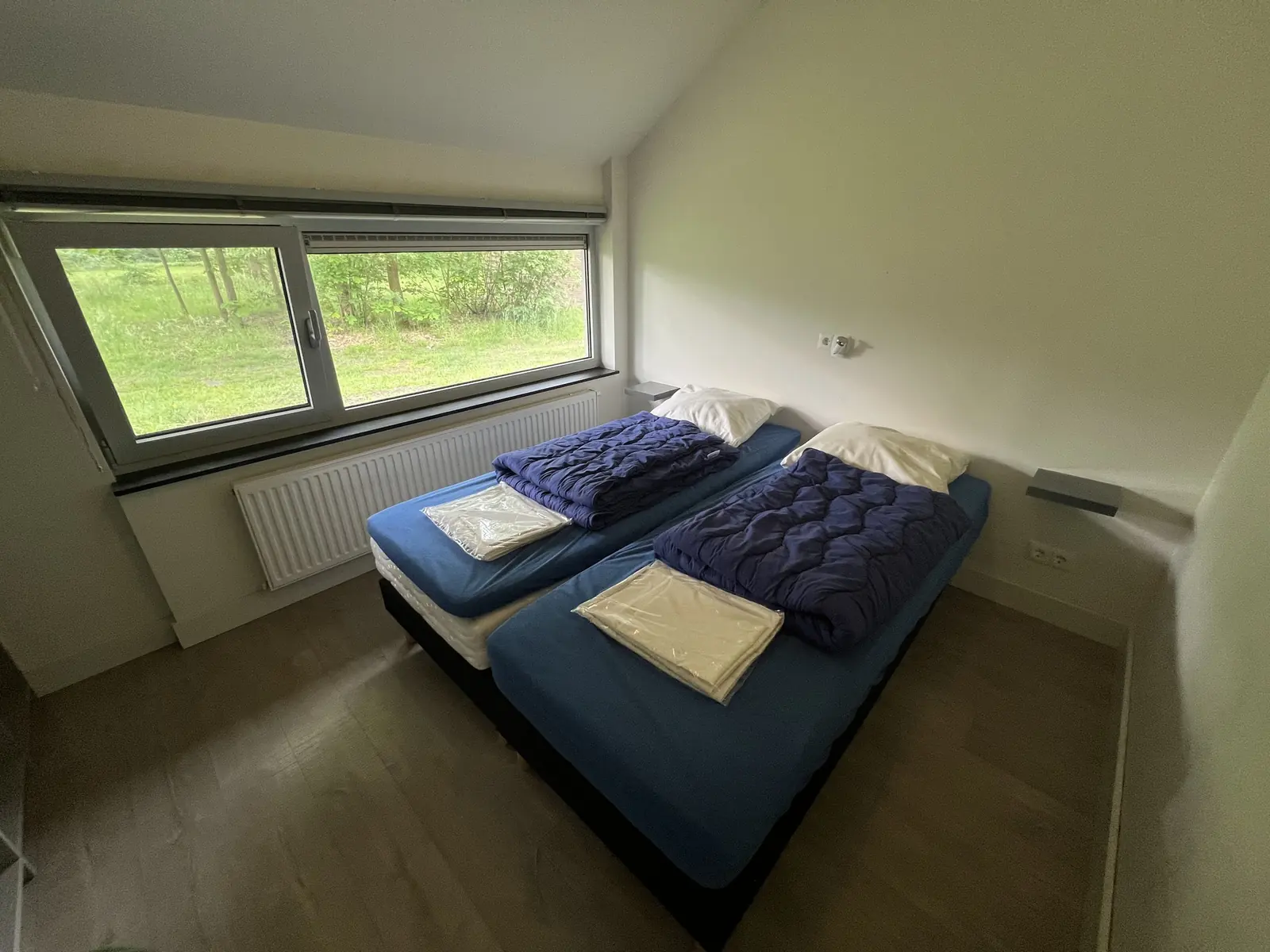Bedroom with two single beds and a wide window