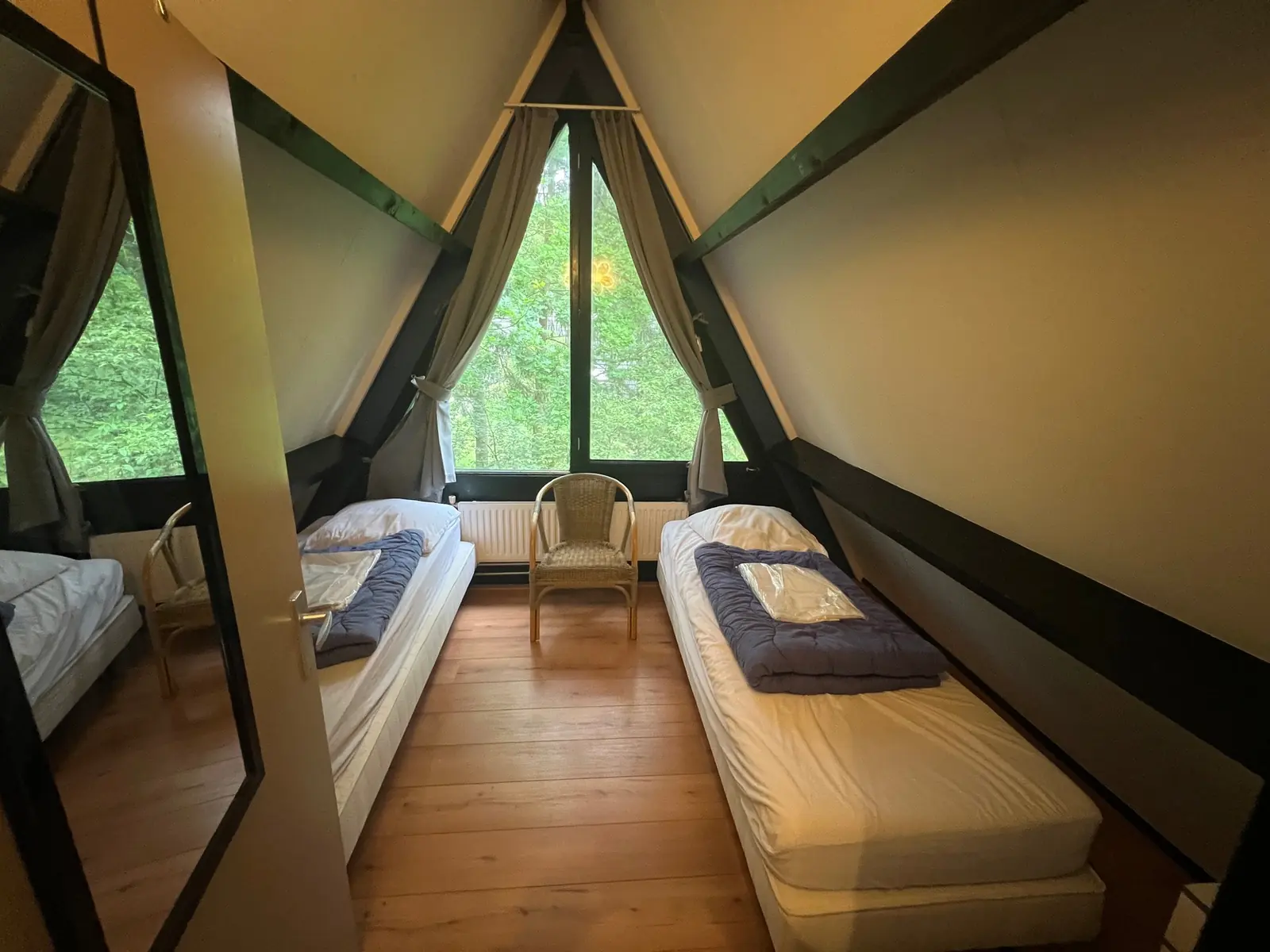 Upstairs bedroom with two single beds and the triangular window