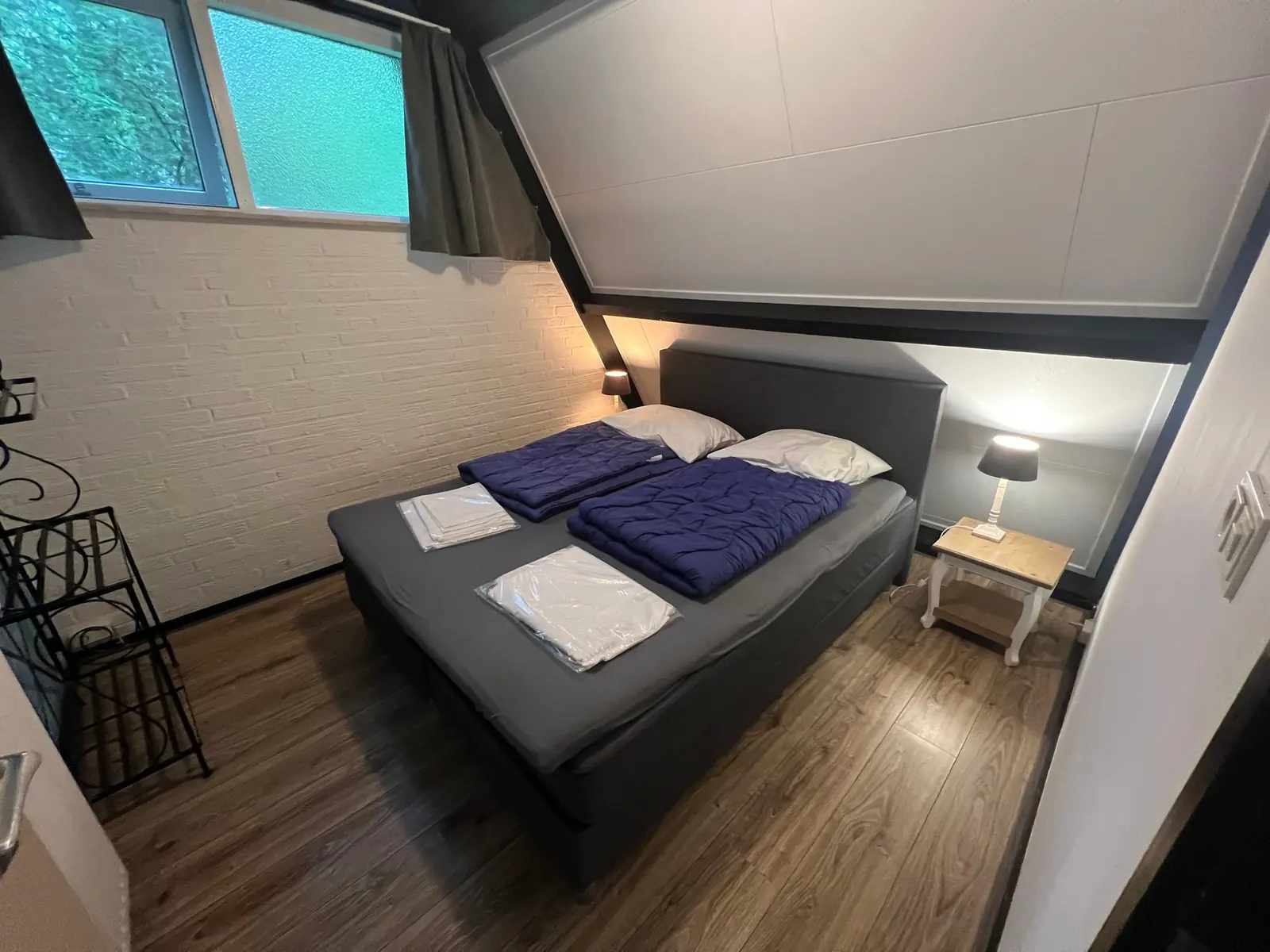 Bedroom with a double bed and a white brick wall