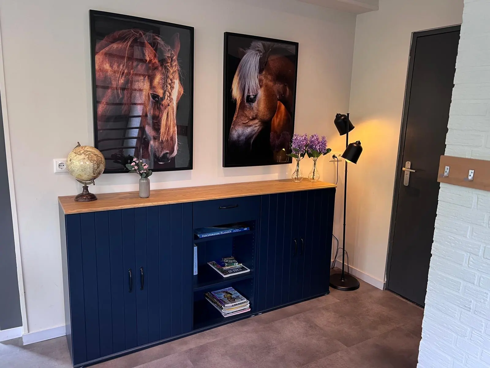 The sideboard in the hall with two horse portraits
