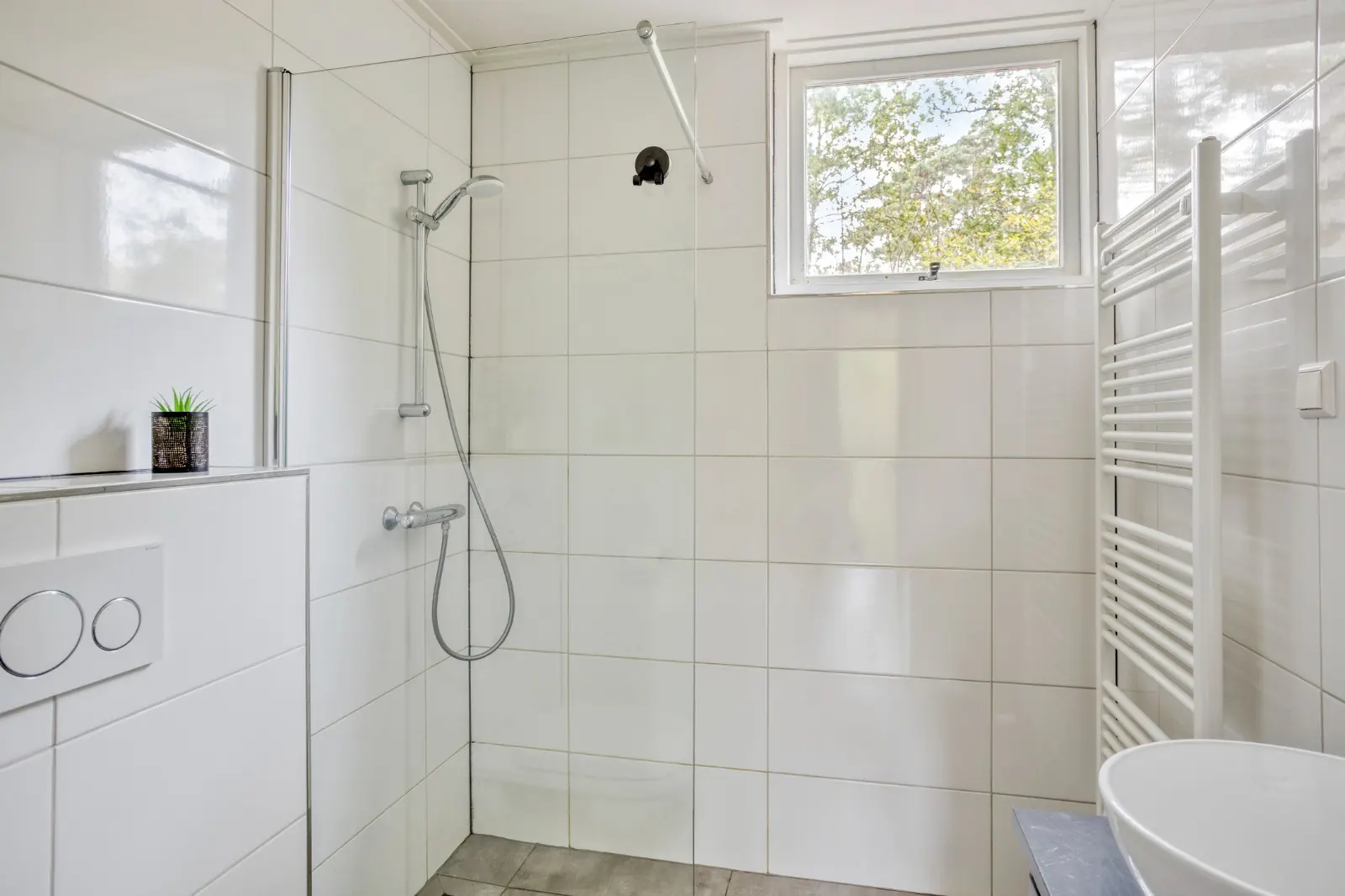 Badkamer met douche en handdoekradiator