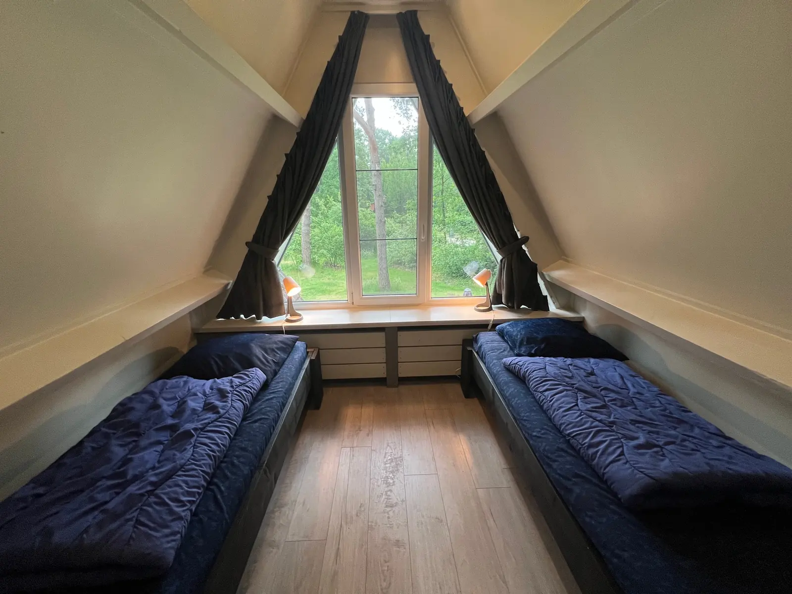 Upstairs bedroom with two single beds and the triangular window