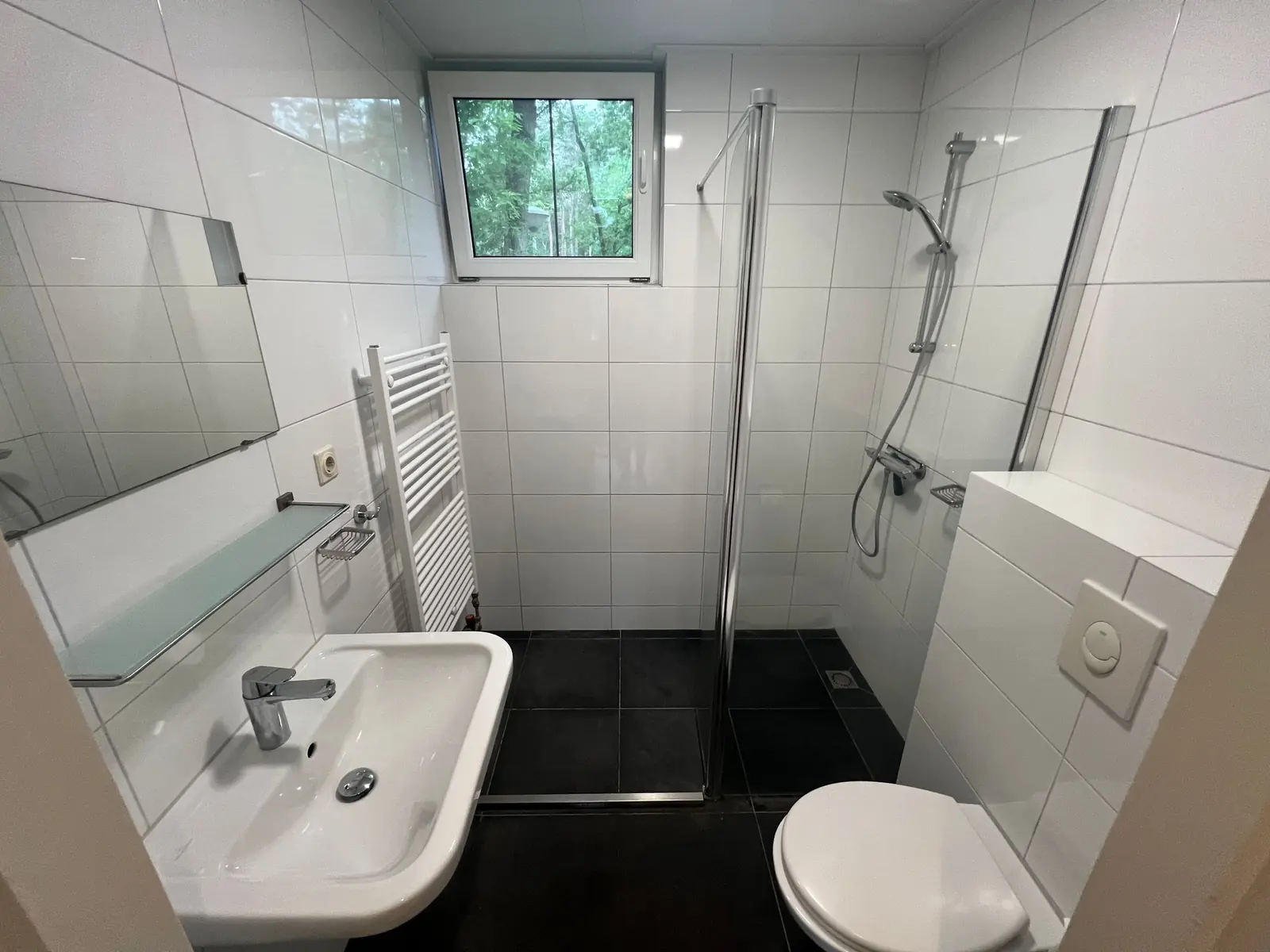 Bathroom with walk-in shower, washbasin and wall-hung toilet