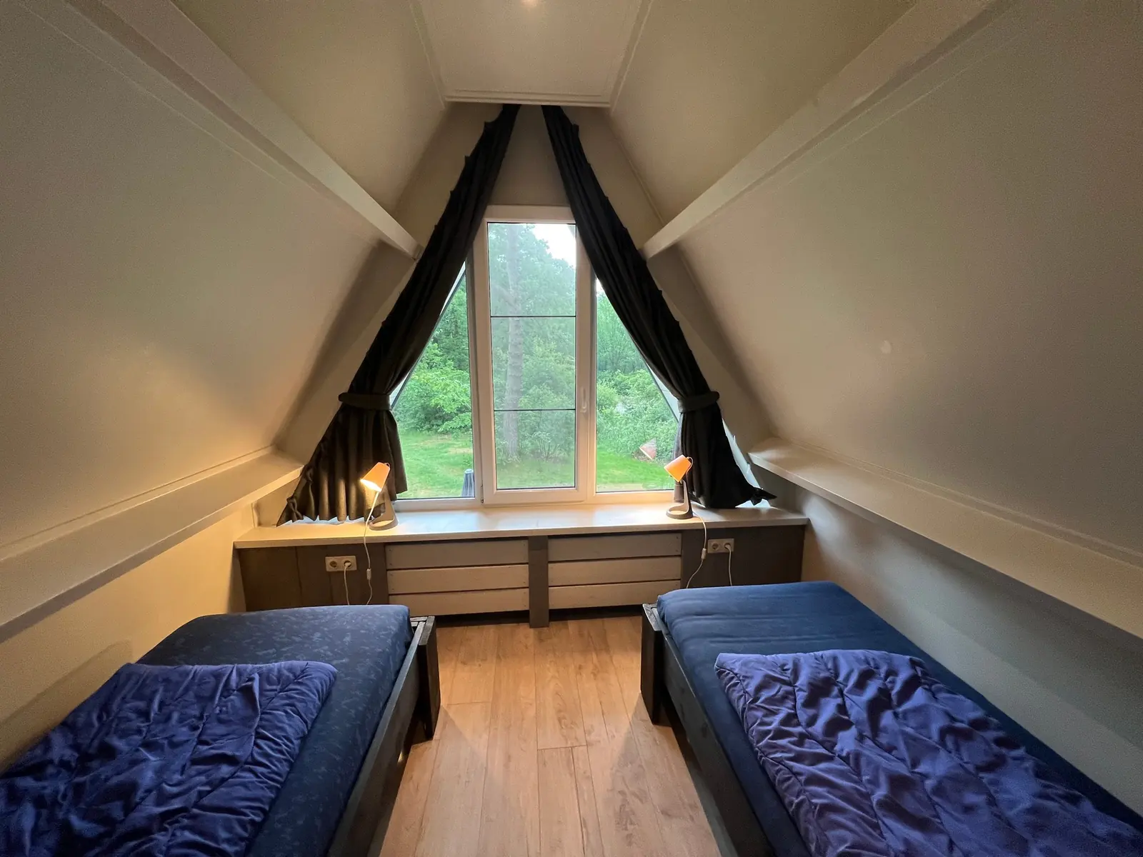 Upstairs bedroom with two single beds and the triangular window