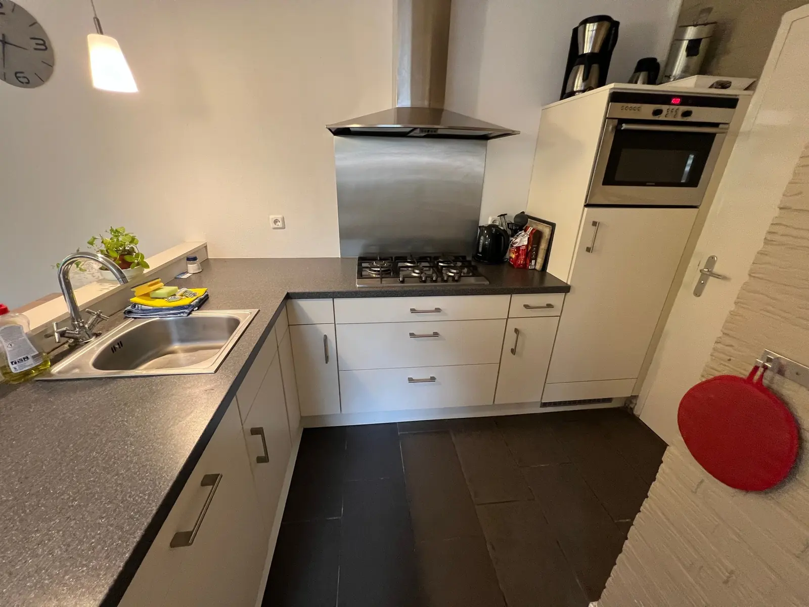 Kitchen with gas hob, extractor hood, oven and sink