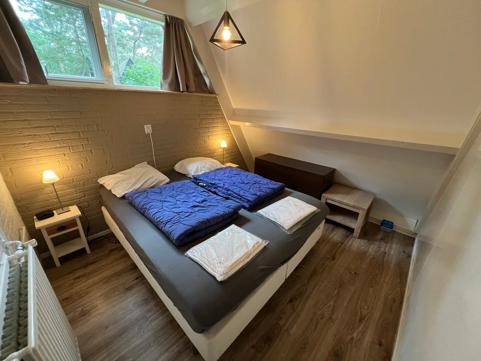 Bedroom with a double bed and a wide window above it