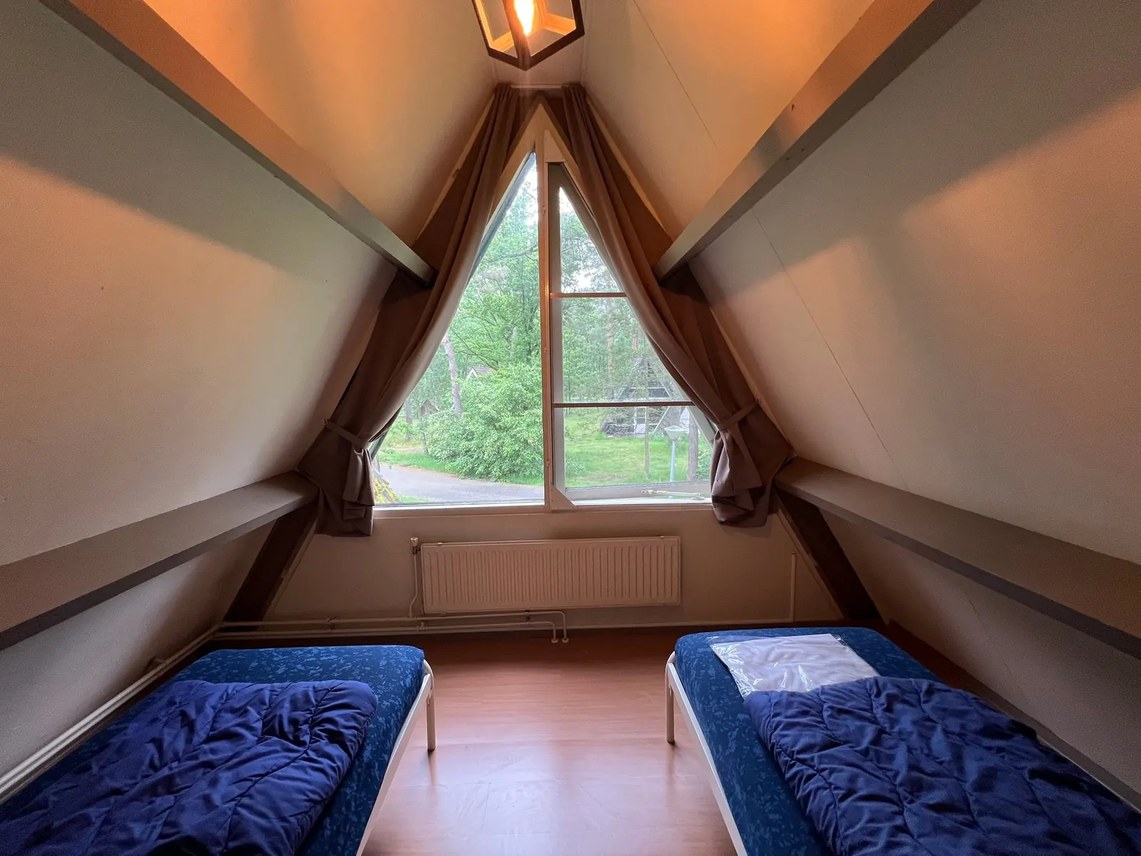 Upstairs bedroom with two single beds and the triangular window